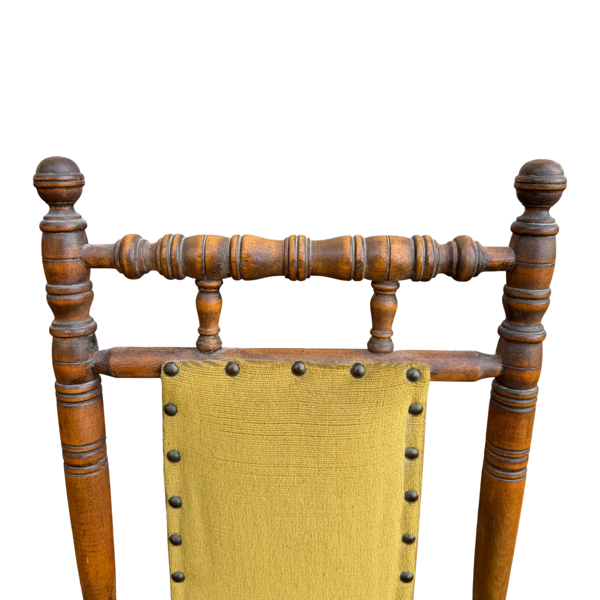 Front view of child-sized rocking chair with turned spindles and upholstered seat