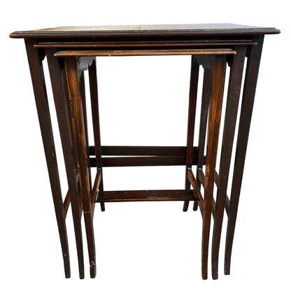 Side view of vintage nesting tables showing dark stained legs and slatted design