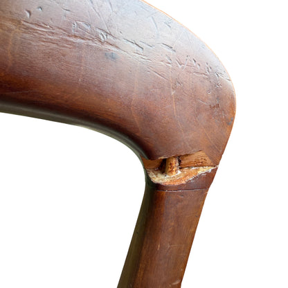 Front view of two upholstered dining chairs with green seat fabric and turned legs