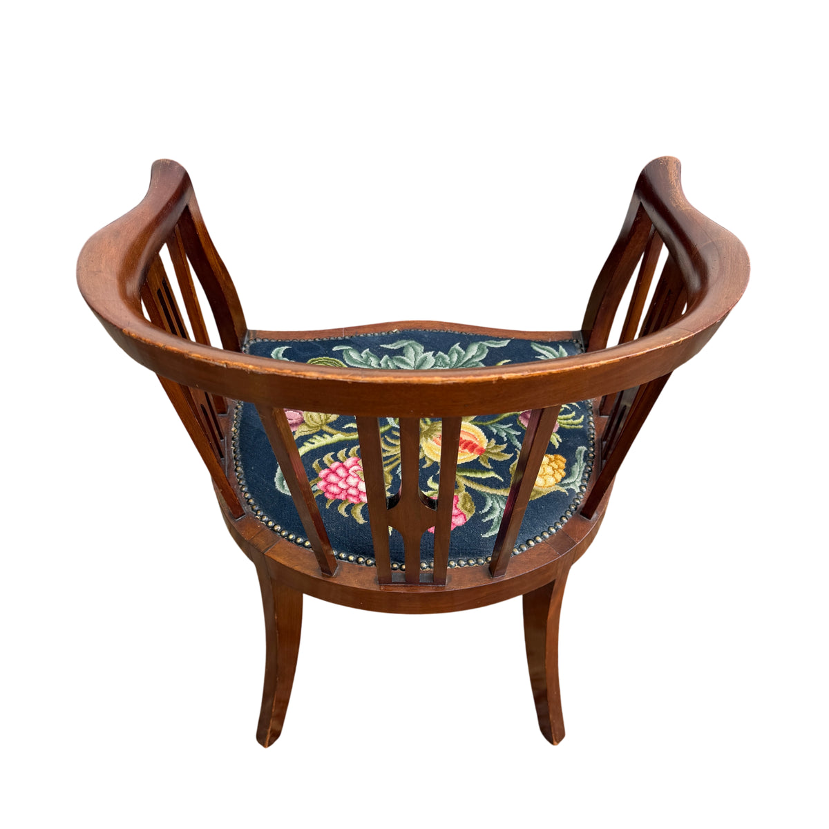 Three-quarter view of tub chair showing arms, slatted back and upholstery