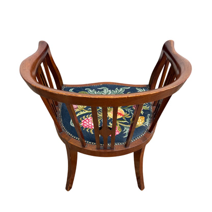 Three-quarter view of tub chair showing arms, slatted back and upholstery