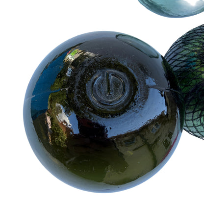 Dark olive vintage glass fishing float showing mould seam and pontil scar