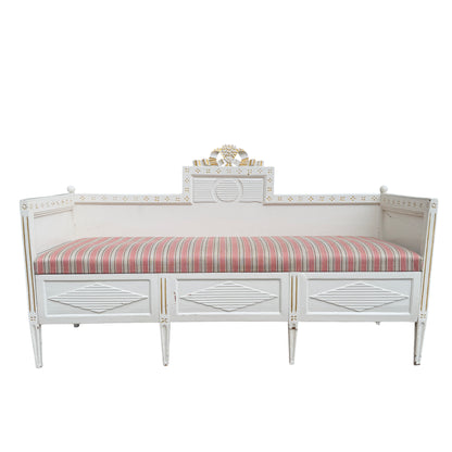 Painted wooden daybed with pull-out base and gilt highlights on carved crest