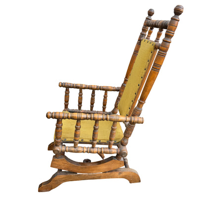 Small children's rocking chair with turned spindle wooden frame and worn finish