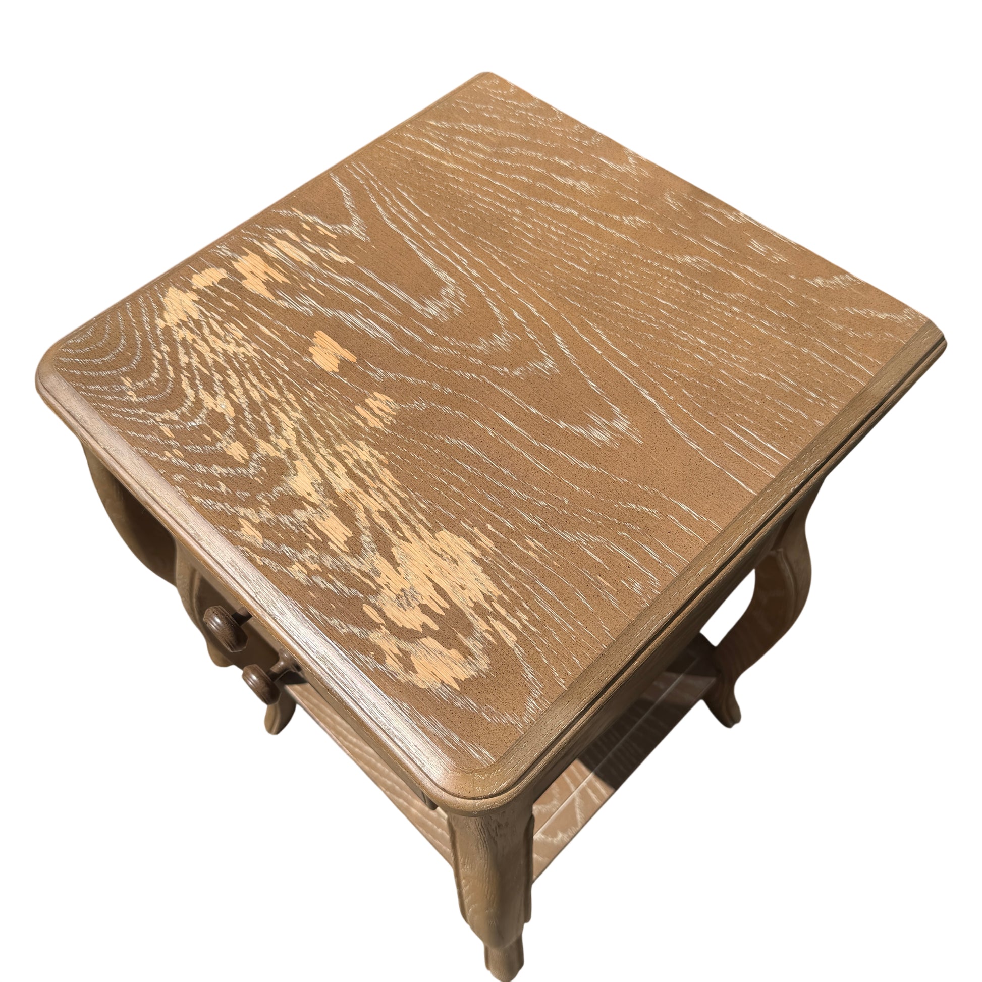 Side view showing shaped cabriole-style leg and lower shelf of bedside table