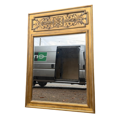 Large contemporary gold overmantel mirror with carved decorative top panel and bevelled glass