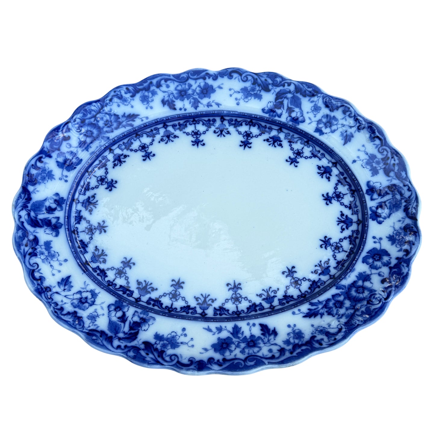 Close-up of scalloped rim and blue floral transferware border on Staffordshire platter