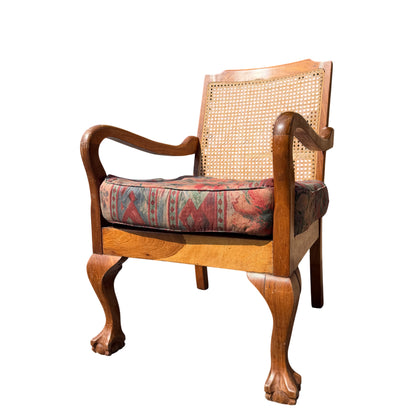 Front view of vintage cane back armchair with upholstered cushion